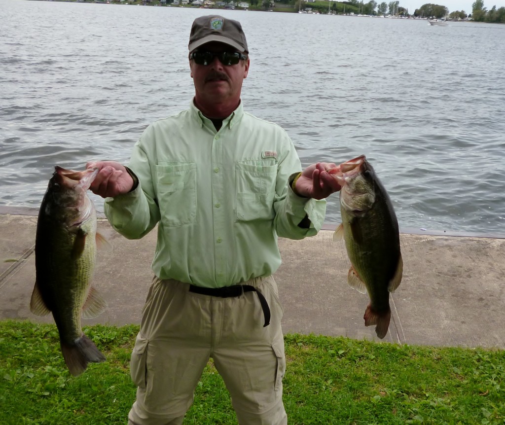 Mike Dixon with a couple of nice large mouth bass.  one of which is 4.97 lbs.
